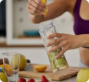 A woman squeezes lemon juice into her drink